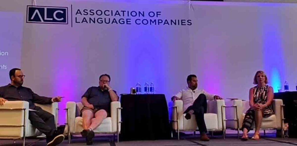 Four people, including CLI's CEO Kristin Quinlan, are sitting on a stage speaking on a panel at a conference hosted by the Association of Language Companies.