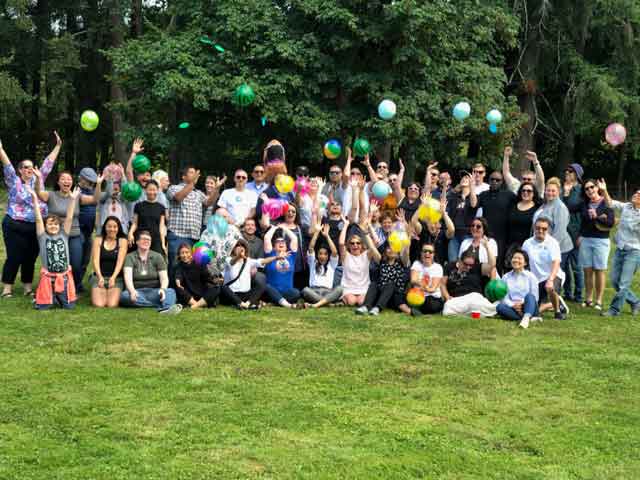 Group of employees from CLI smiling after win at human foosball tournament