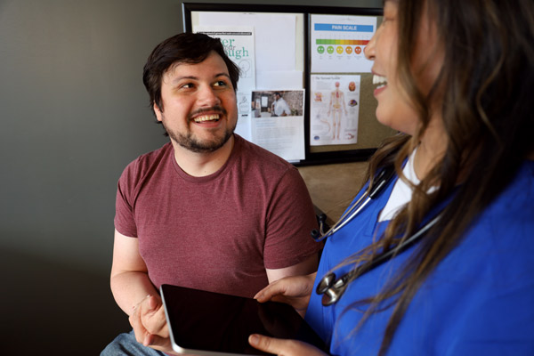 A healthcare professional and a patient speak with the help of a medical interpreter.