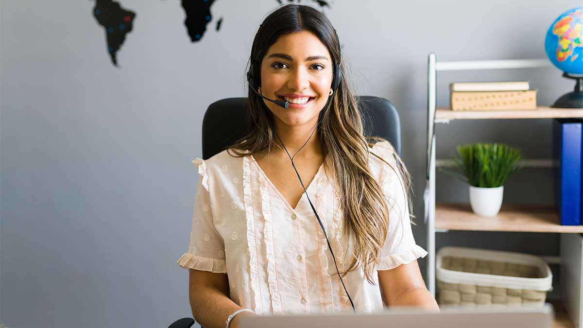 A confident Spanish interpreter smiles at their desk, knowing they're doing their job effectively.