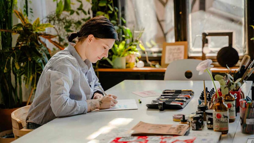 A translator sits at their desk with a pen and paper to work on a translation.