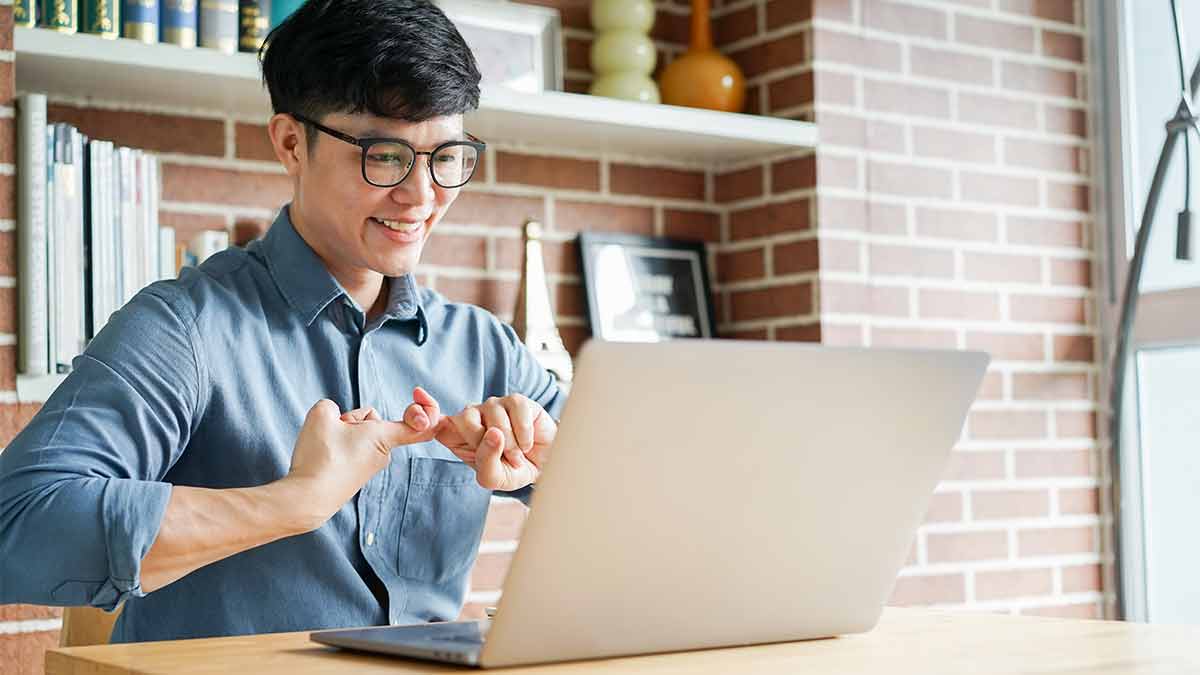 An American Sign Language interpreter on a laptop signs the word friend.