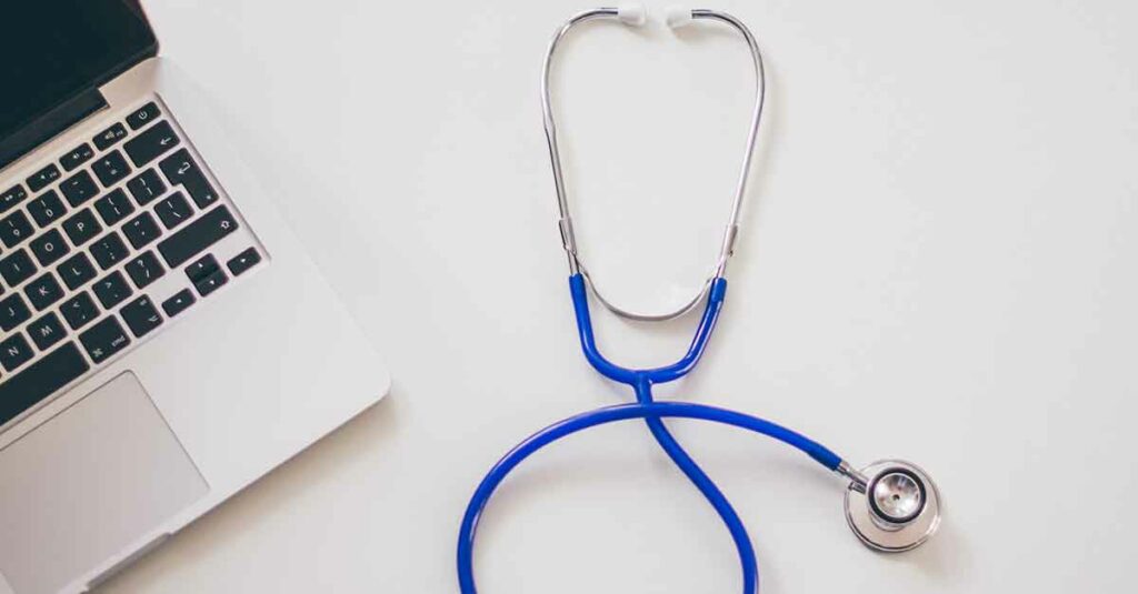 Open laptop that provider uses for telemedicine encounter sitting next to a stethoscope.