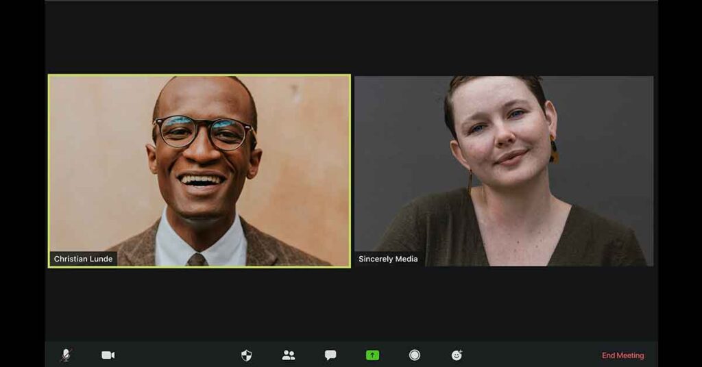 Two people on a video conference call. One person has a light neutral background and the other person has a dark neutral background. Both backgrounds are appropriate for a video interpreter.