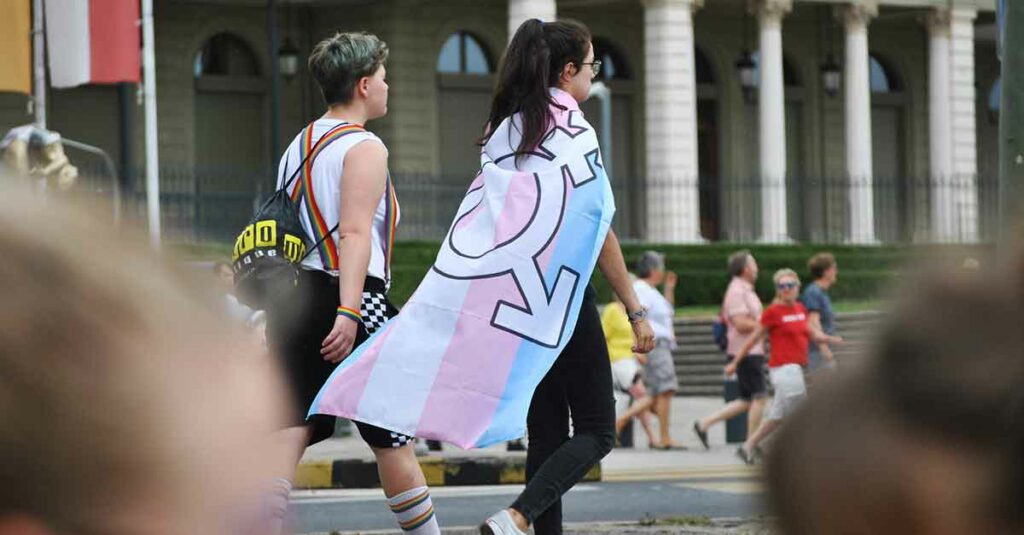 Two gender-neutral people walking down the street