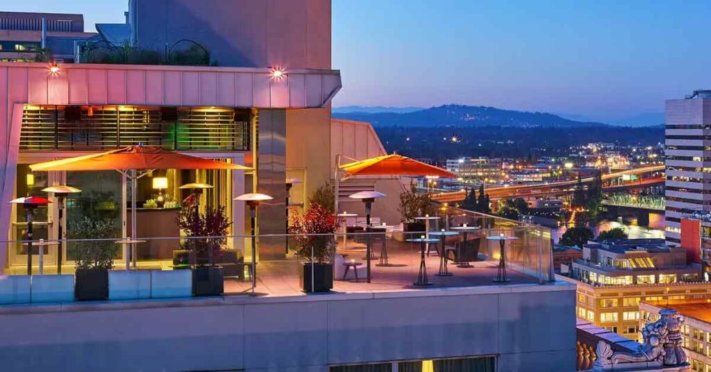 Departure, a rooftop bar, overlooks the vibrant city of Portland at sunset.