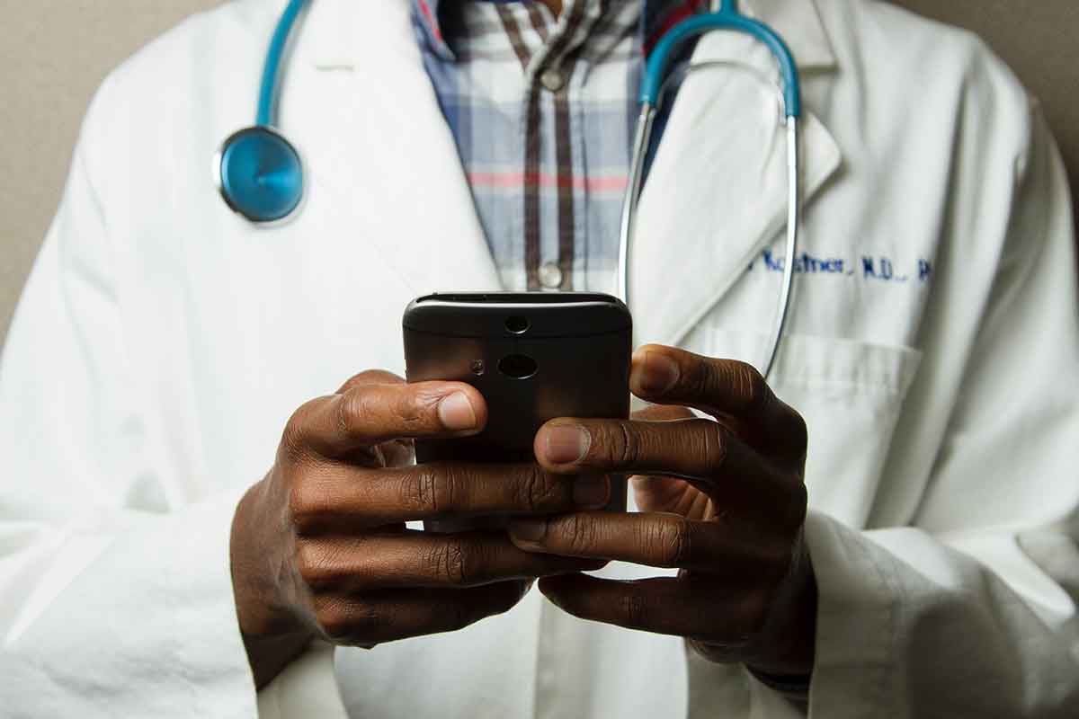 Male doctor holding a smartphone and about to access a remote interpreter