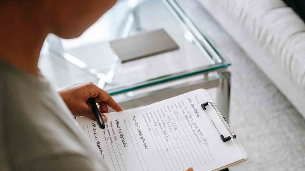 Female provider filling out a medical questionnaire for her non-English-speaking patient.