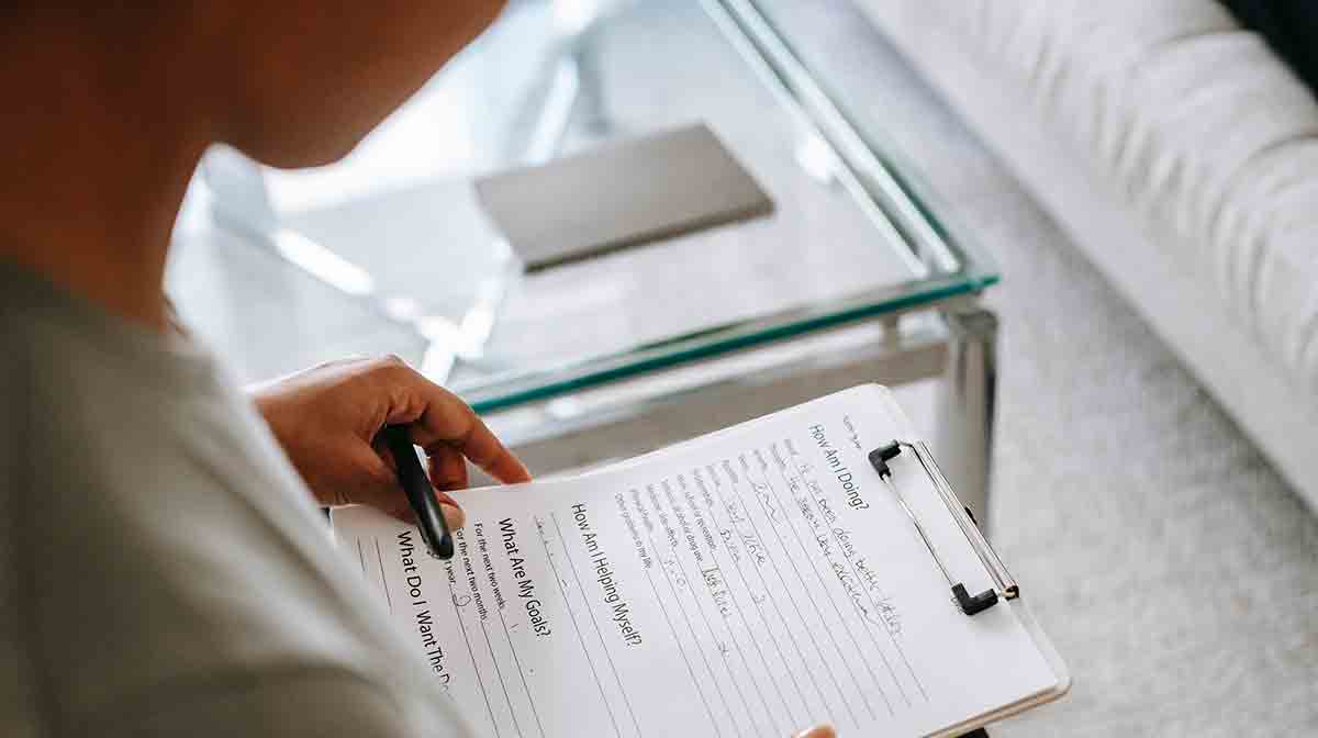 Female provider filling out a medical questionnaire for her non-English-speaking patient.