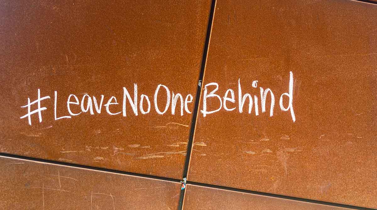 Burned orange tiled floor with "#LeaveNoOneBehind" written in chalk.