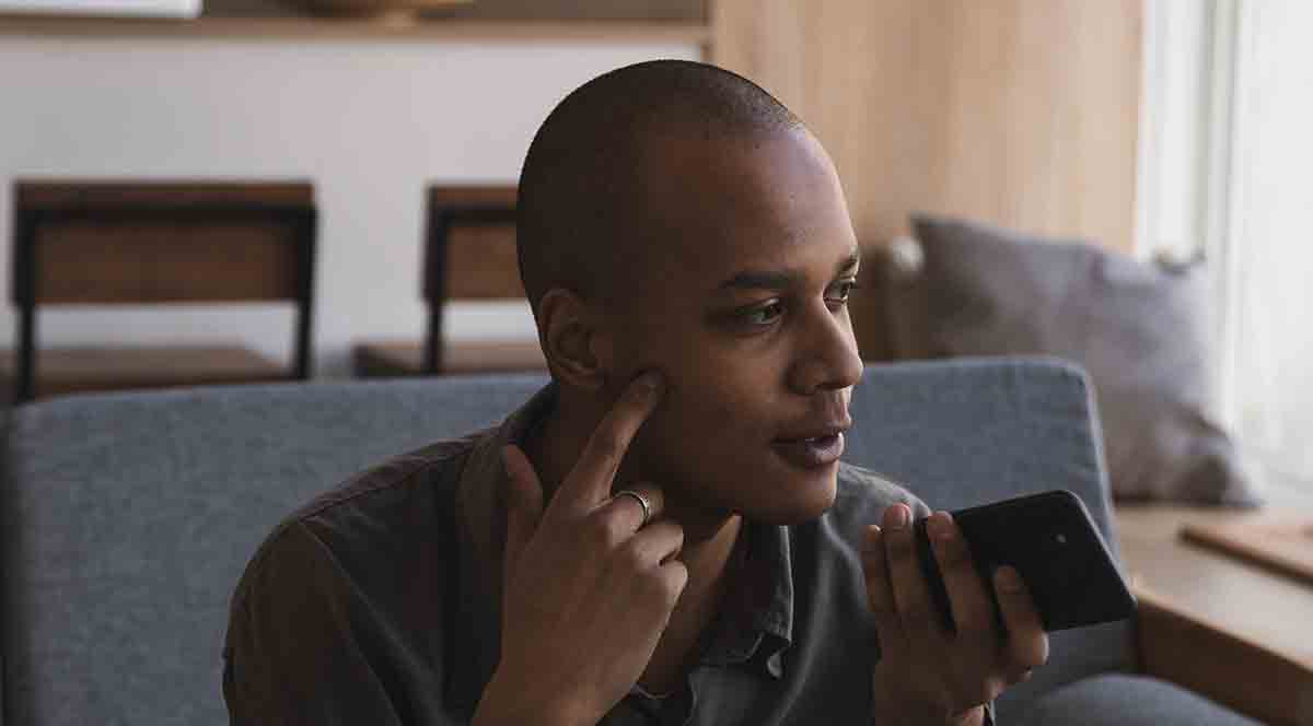 Man using his smartphone to talk to his doctor from home.