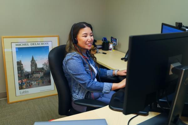 An interpreter smiles as they take a call to get an insurance claim processed.