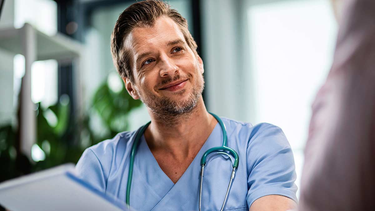 A smiling doctor holds language access plan documents.