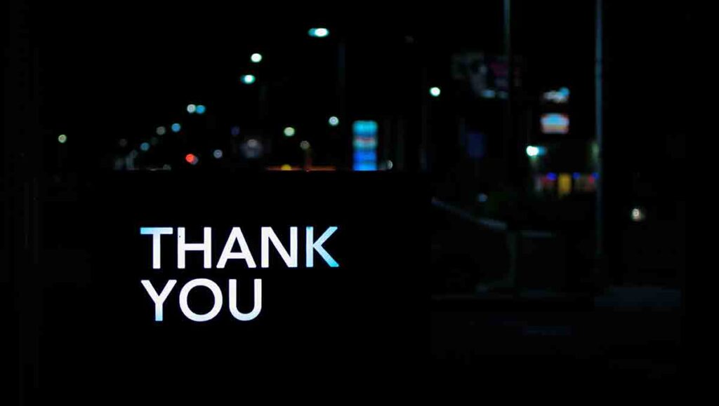 White thank you written over dark cityscape