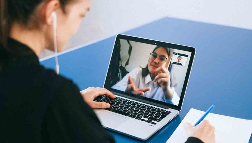 A sign language staff medical interpreter in a micro call center communicating with a woman.