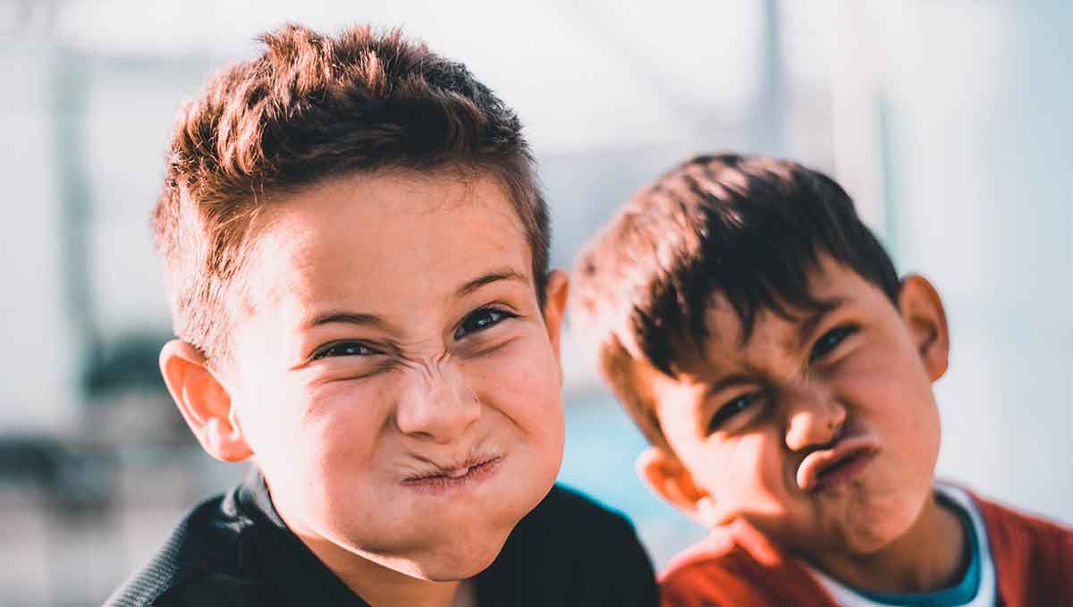 Two young males making silly faces at the camera.