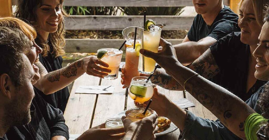 A group of friends toast on the patio of Victoria Bar in Portland, OR.