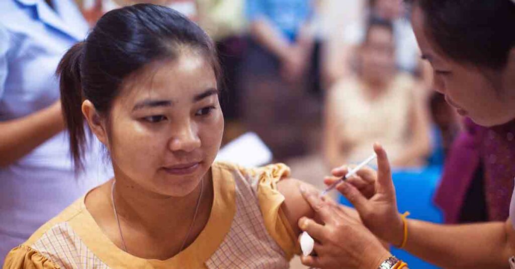 Female clinician providing a vaccine to a female patient