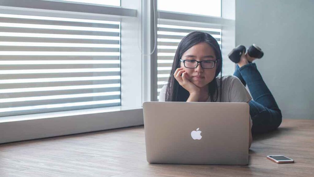 Woman looks at laptop to access an interpreter for telehealth services.