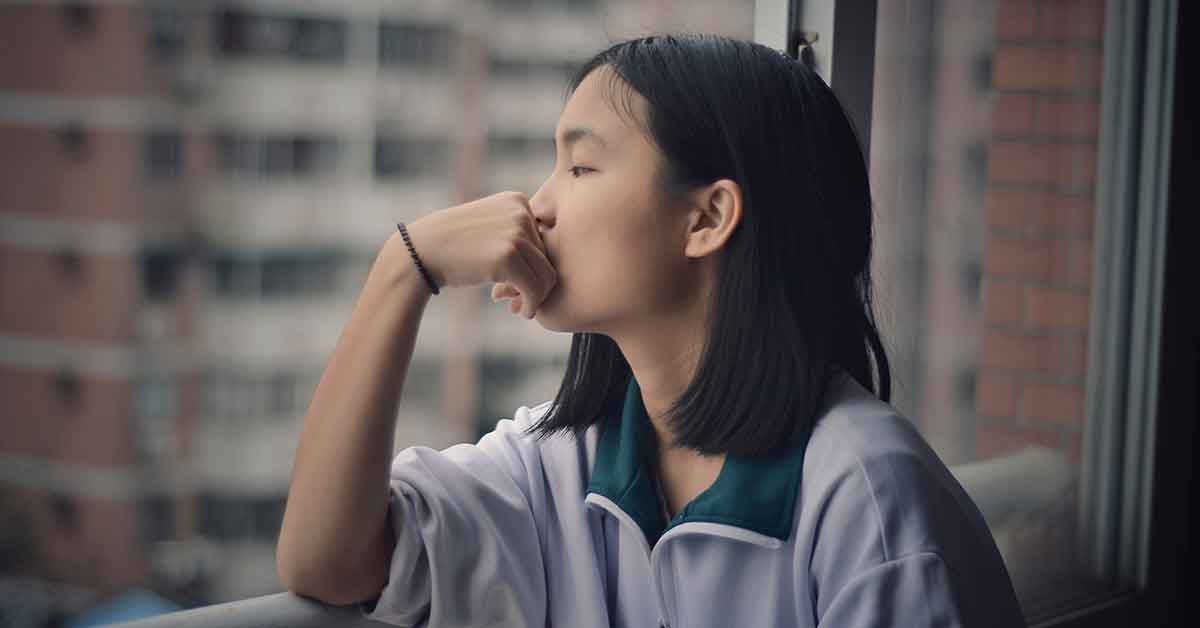 Female interpreter looking out a window taking some time for a self-assessment.