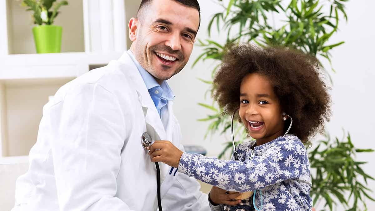 A child uses a stethoscope on a pediatrician in the children's hospital.